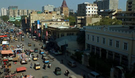 Street fruit vendor in Karachi with seasonal mangoes and citrus displayed